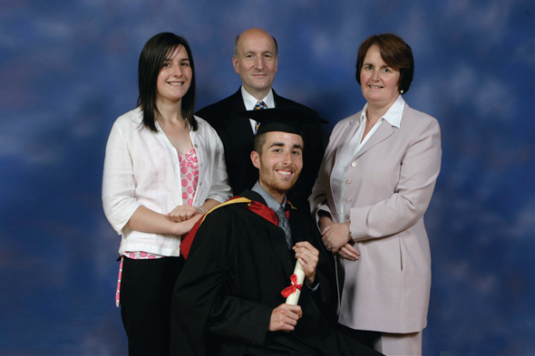Jack with family, posing for graduation photo.